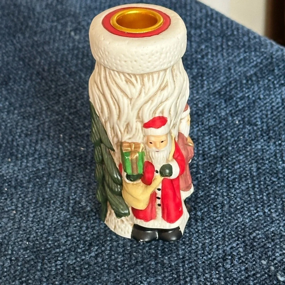 Cute Santa ceramic candleholder. Multiple smaller Santas surrounding the holder.